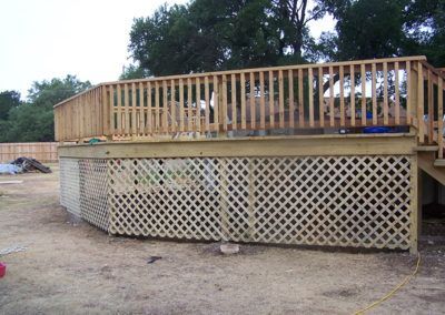 A wooden deck with a lattice fence around it