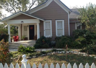 A small house with a white picket fence in front of it