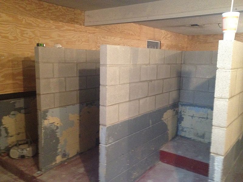 A bathroom with brick walls and a shower stall.