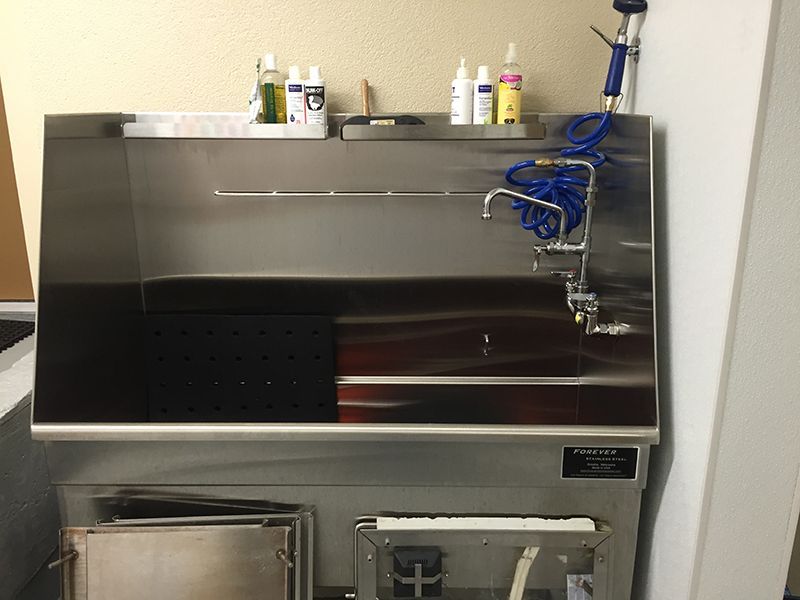 A stainless steel sink with a hose attached to it