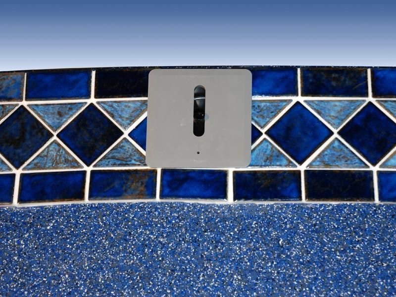 Blue mosaic tile wall with a gray electrical outlet plate above a speckled blue surface