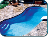 Backyard swimming pool with bright blue water and a stone deck around it