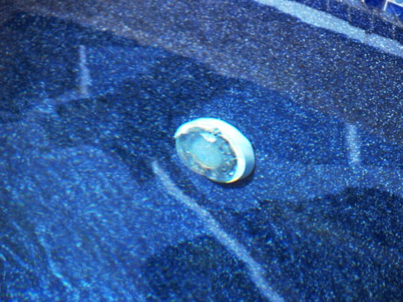 Blue car door handle with a chrome lock button close-up