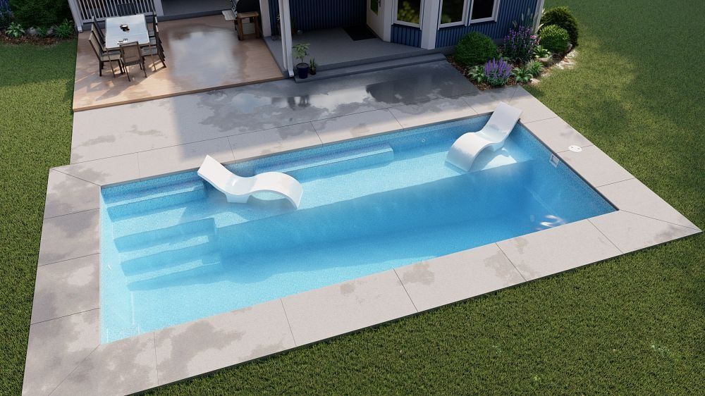 Backyard pool with blue water and white built-in lounge seats, bordered by a stone patio and grass