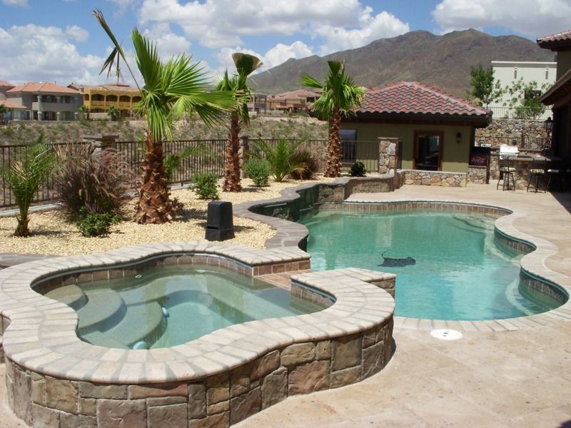 Backyard with a small pool, stone spa, palm trees, and a patio with a tile-roofed pavilion