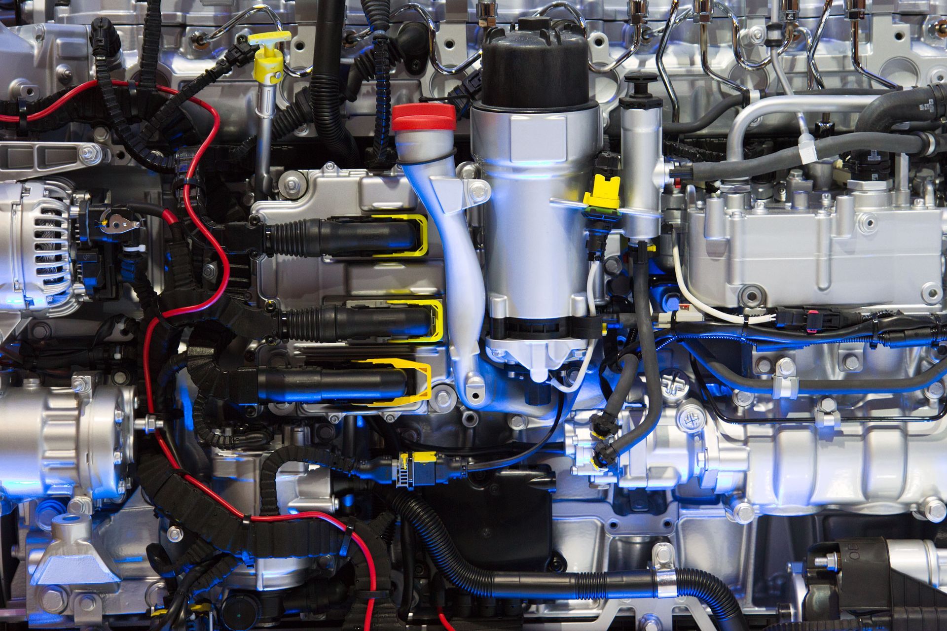 Close-up of a complex engine, with various pipes, wires, and mechanical parts, metallic with some colorful accents.