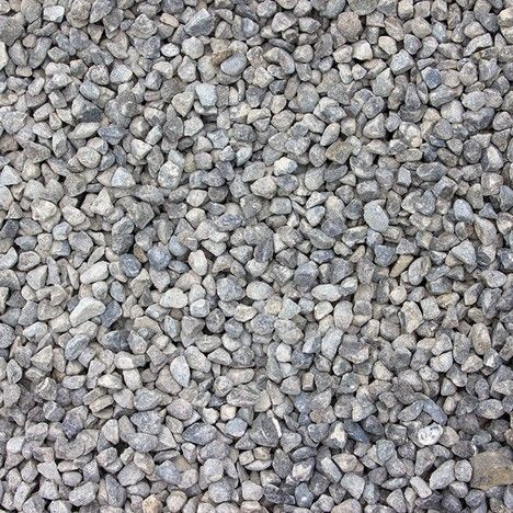 A dense, top-down view of small, jagged gray and light-brown gravel stones packed closely together.