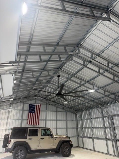 Jeep parked inside a metal garage with an American flag hanging on the wall.