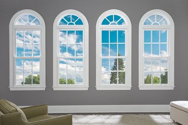 A living room with four arched windows and a couch.