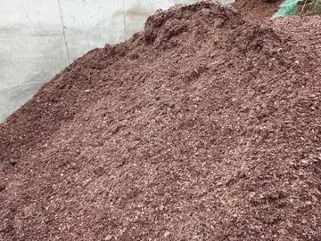 A large pile of coarse, reddish-brown wood mulch or soil amendment.