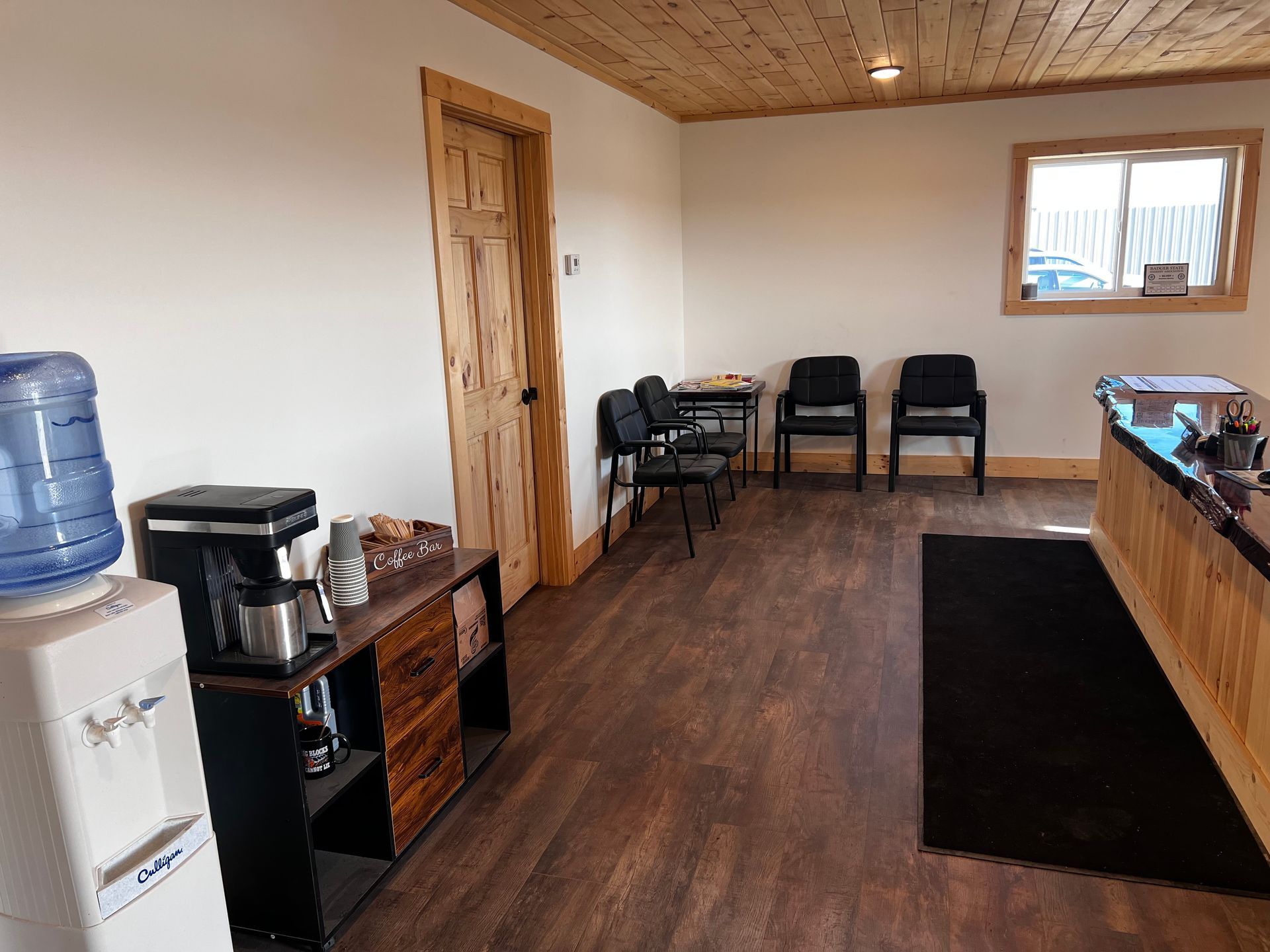 Learn More About Free Estimates A waiting room with wooden floors and a water cooler.