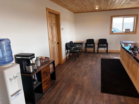 A waiting room with wooden floors and a water cooler.