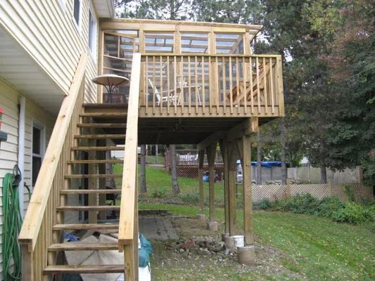Wooden deck with stairs, a screened-in porch, and a yard.
