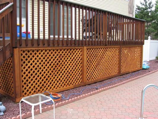 Wooden deck with lattice panels; side of house visible.