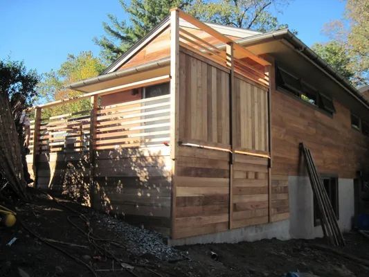 Wooden house with exterior cedar siding and a slatted deck.