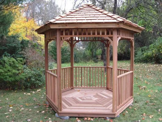 Wooden octagonal gazebo in a grassy yard.