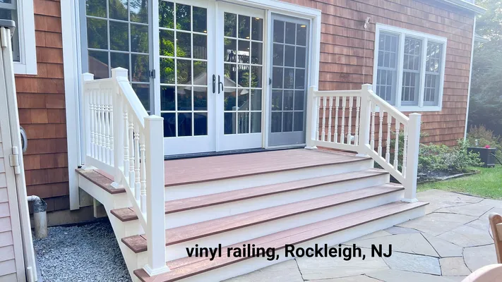 White vinyl railing with steps leading to a house's glass doors in Rockleigh, NJ.