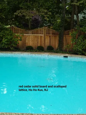Pool with red cedar fence featuring lattice and scalloped top, located in Ho Ho Kus, NJ.