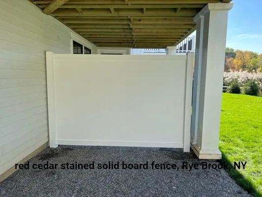 White solid board fence under a porch, Rye Brook, NY.