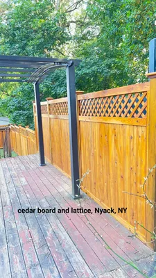 Wooden deck with cedar board fence and lattice detail, Nyack, NY. Black pergola posts.