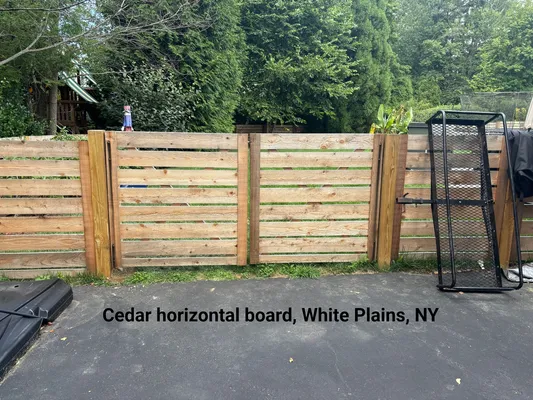 Cedar horizontal board fence in White Plains, NY with a metal frame leaning against it.