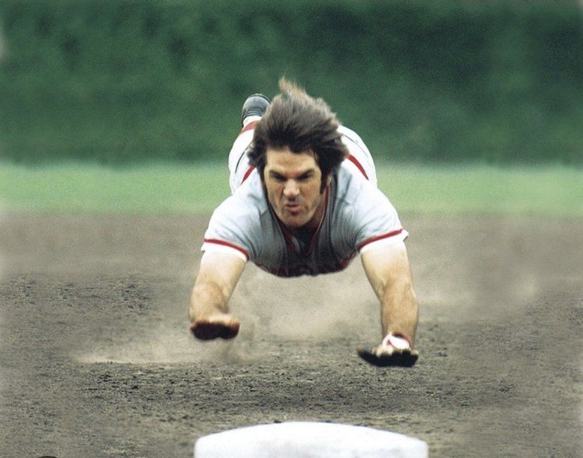 A man is laying on his back on a baseball field.