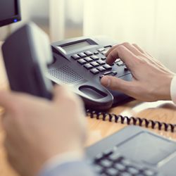 Businessman dialing a number on the telephone