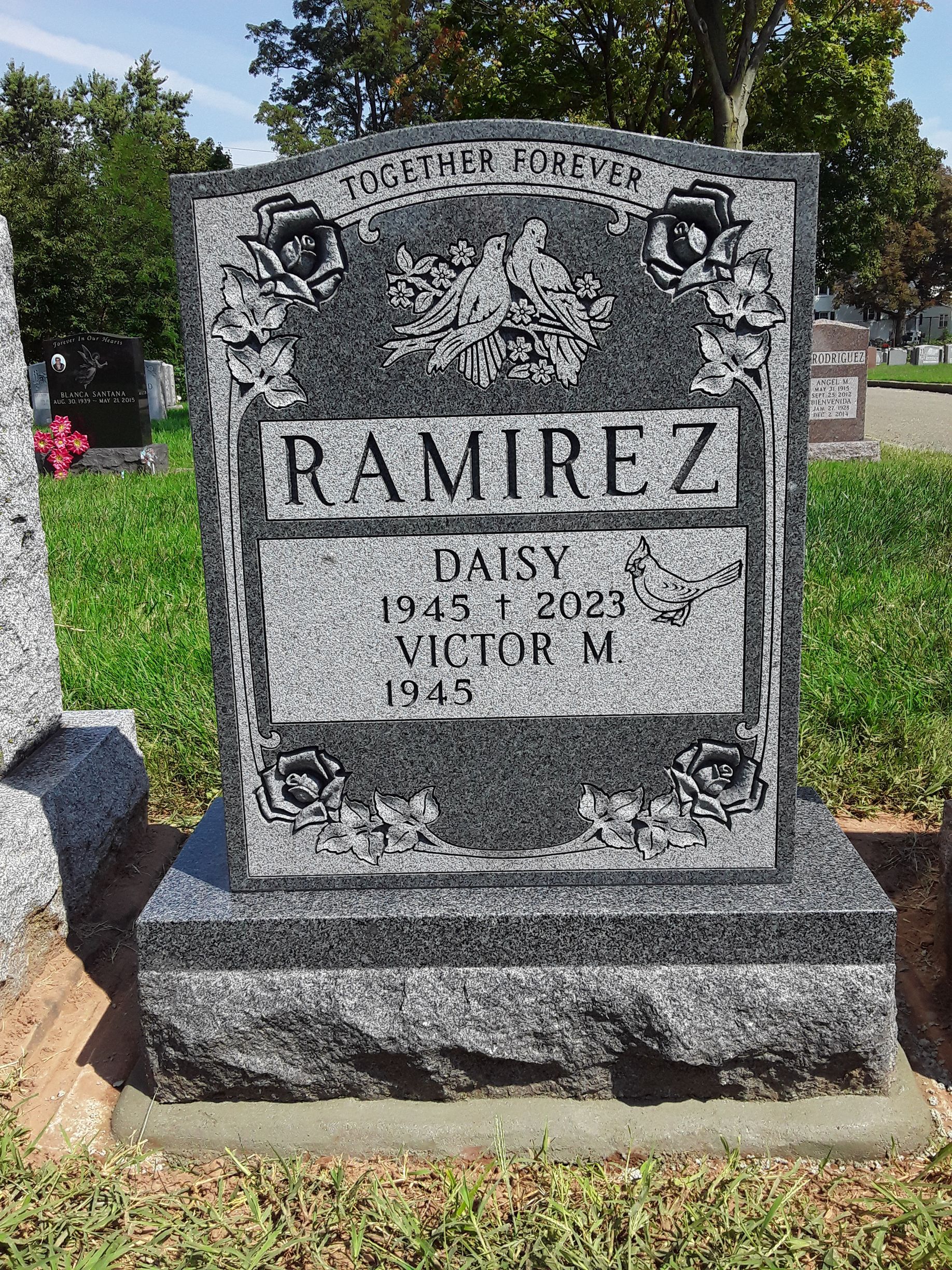 Gray granite Ramirez gravestone in a cemetery, with engraved name and dates.