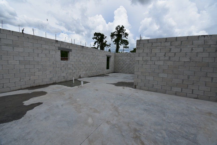 A building under construction with brick walls and a concrete floor
