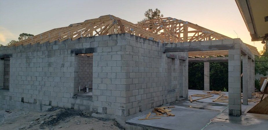 A house is being built with bricks and a wooden roof.