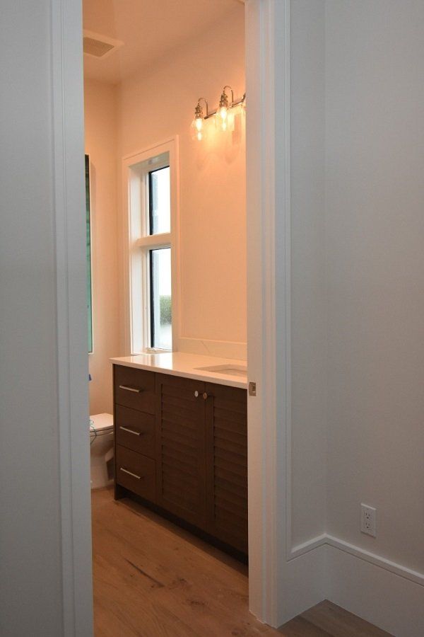A bathroom with a sink, toilet and window.