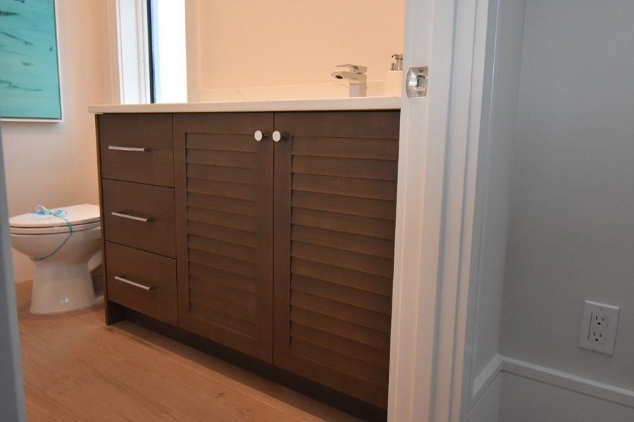 A bathroom with a toilet, sink, and drawers.
