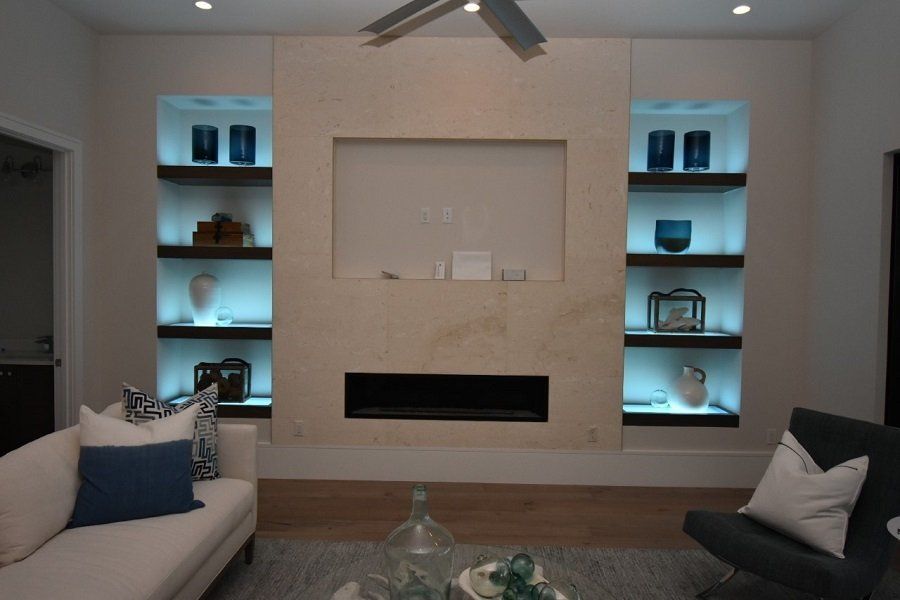 A living room with a fireplace and a ceiling fan