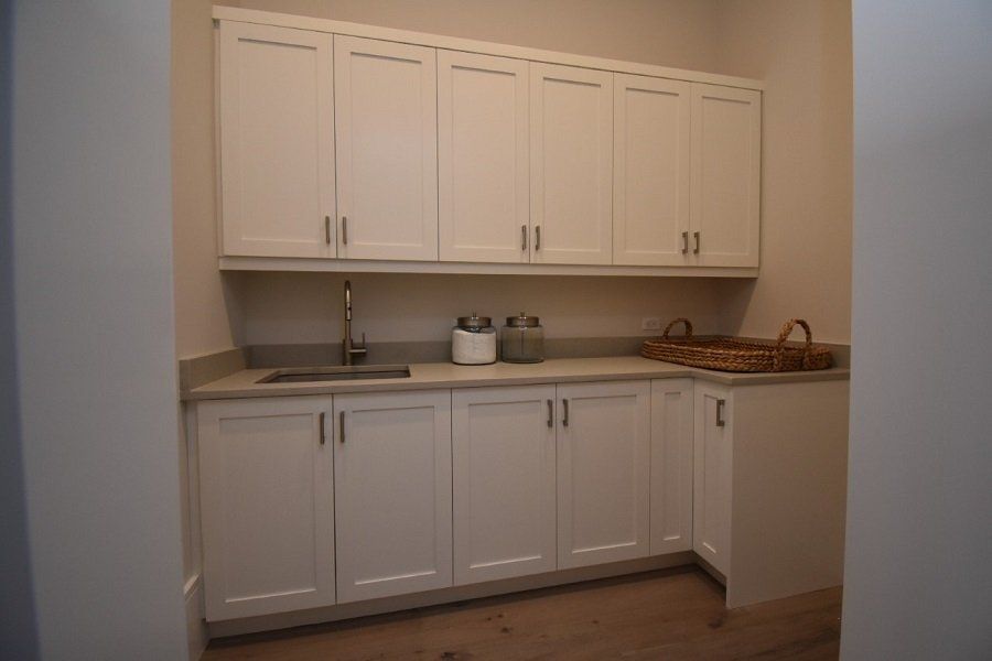 A kitchen with white cabinets and a sink.