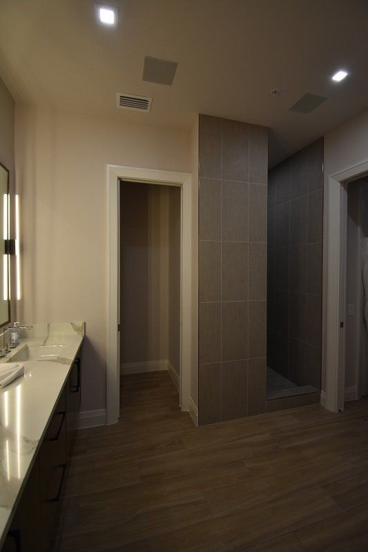 A bathroom with two sinks and a walk in shower.