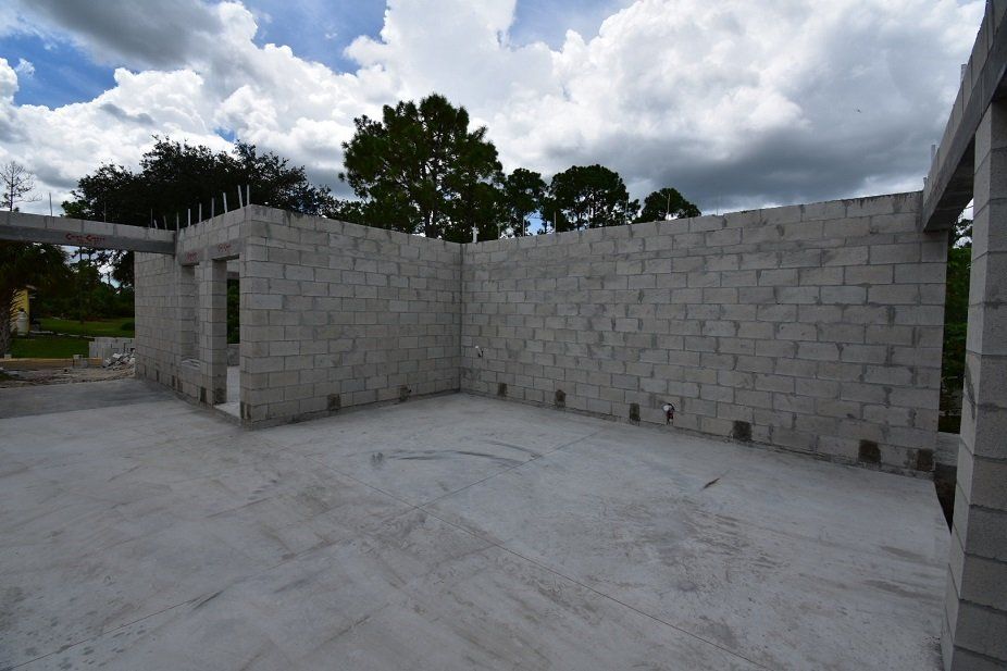 A building under construction with brick walls and a concrete floor.
