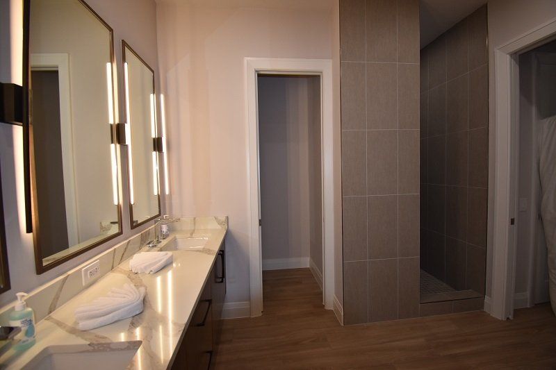 A bathroom with two sinks and a walk in shower.