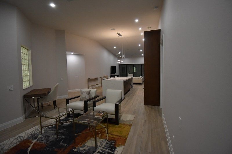A living room with a table, chairs, and a rug.