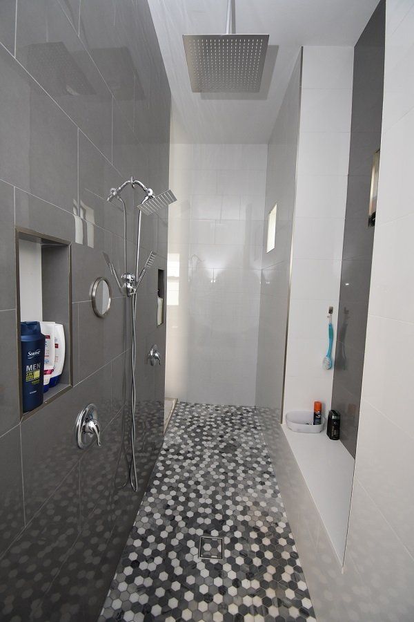 A bathroom with a walk in shower and a shower head