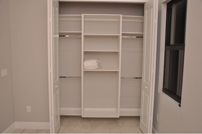 A closet with shelves and a window in a room