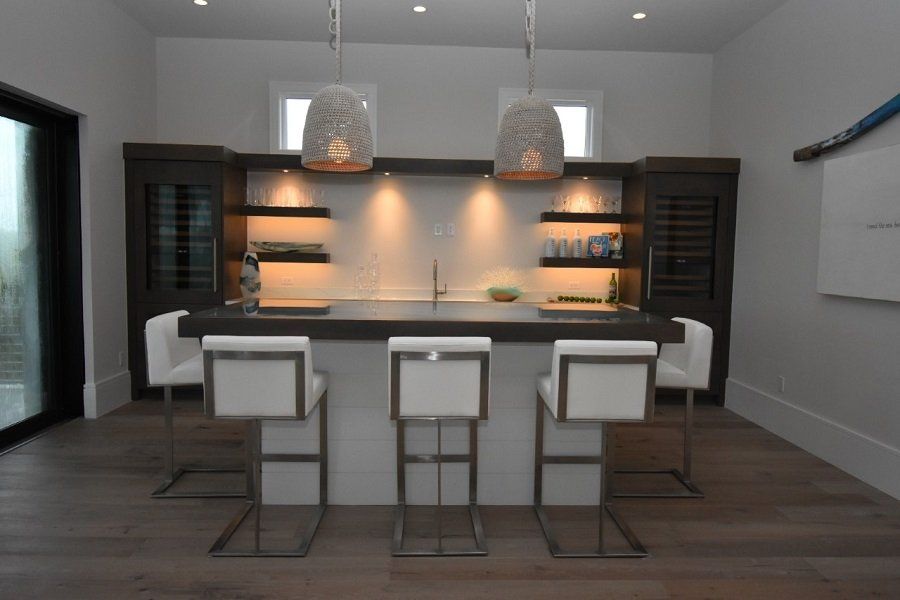 A kitchen with a large island and three bar stools