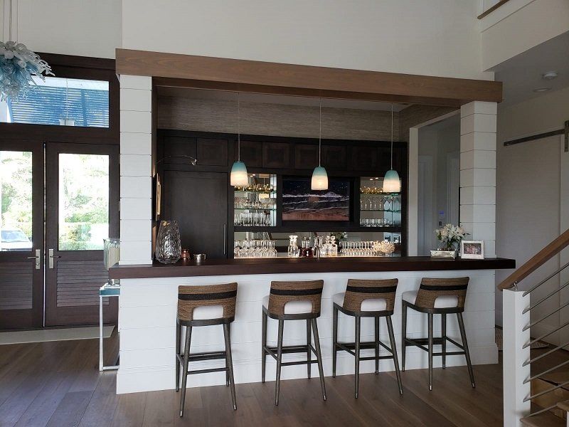 A kitchen with a bar and four stools