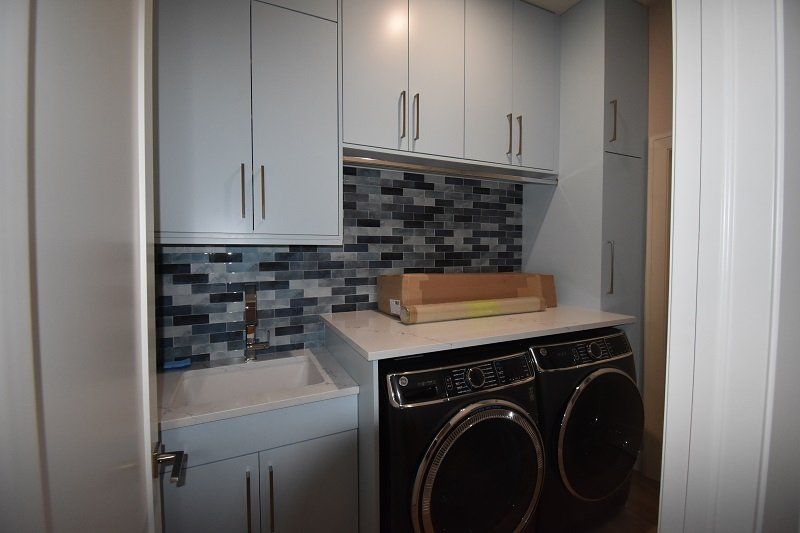 A laundry room with a washer and dryer and a sink.
