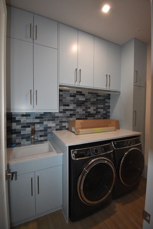 A laundry room with a washer and dryer and a sink
