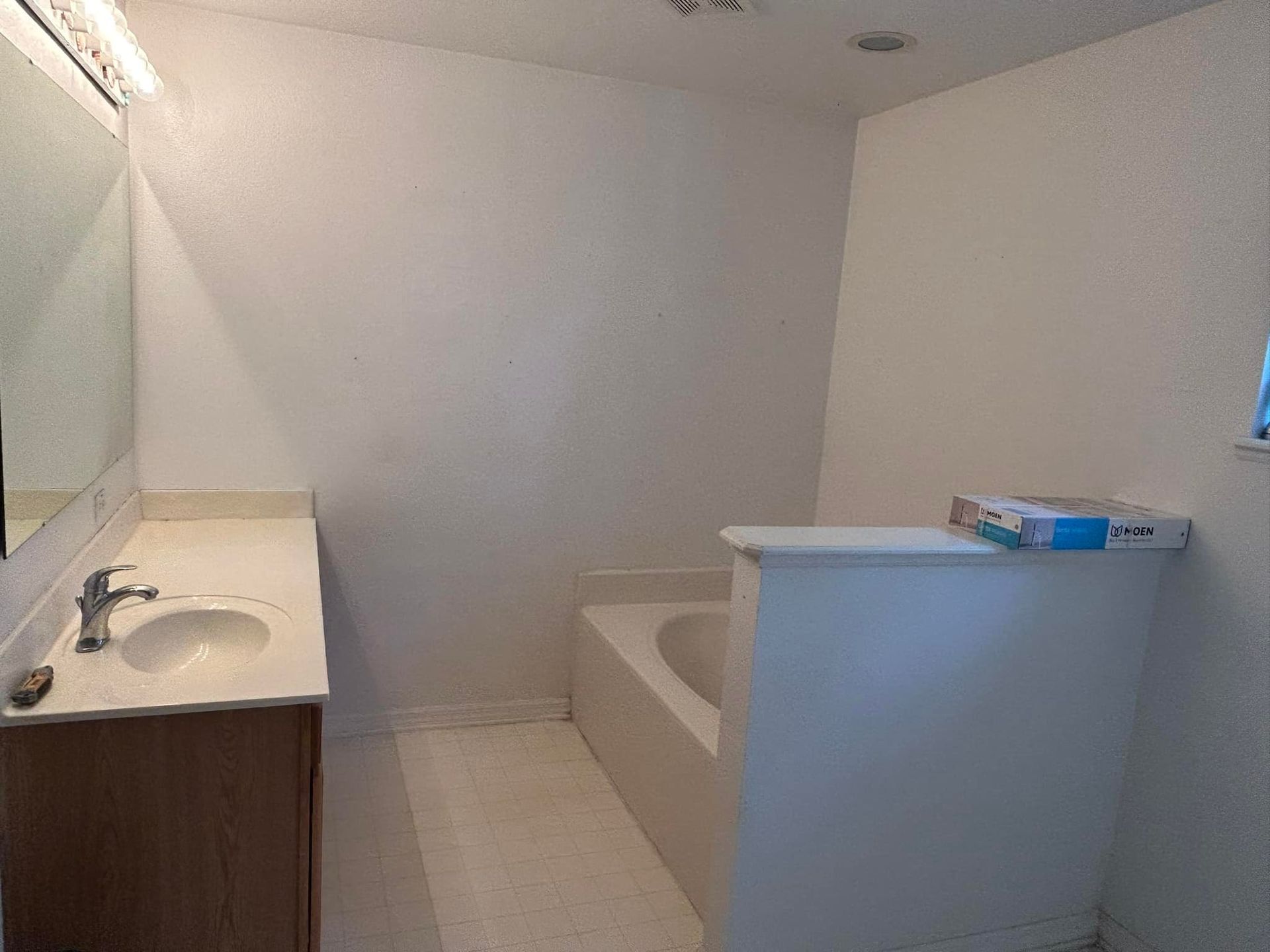 Bathroom with a sink, bathtub, and white walls.