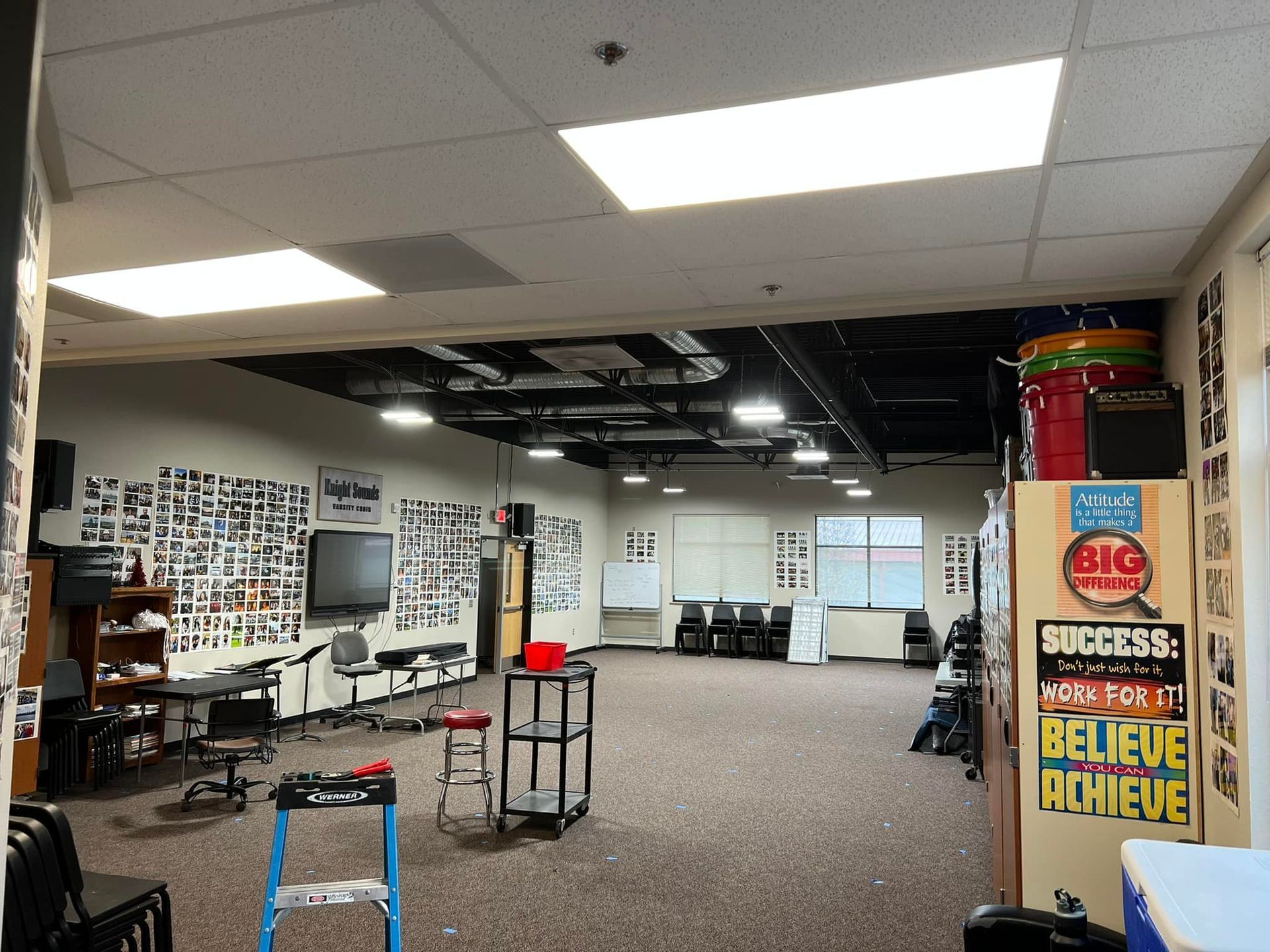 A music room with a partially exposed ceiling, instruments, and walls covered in photos.