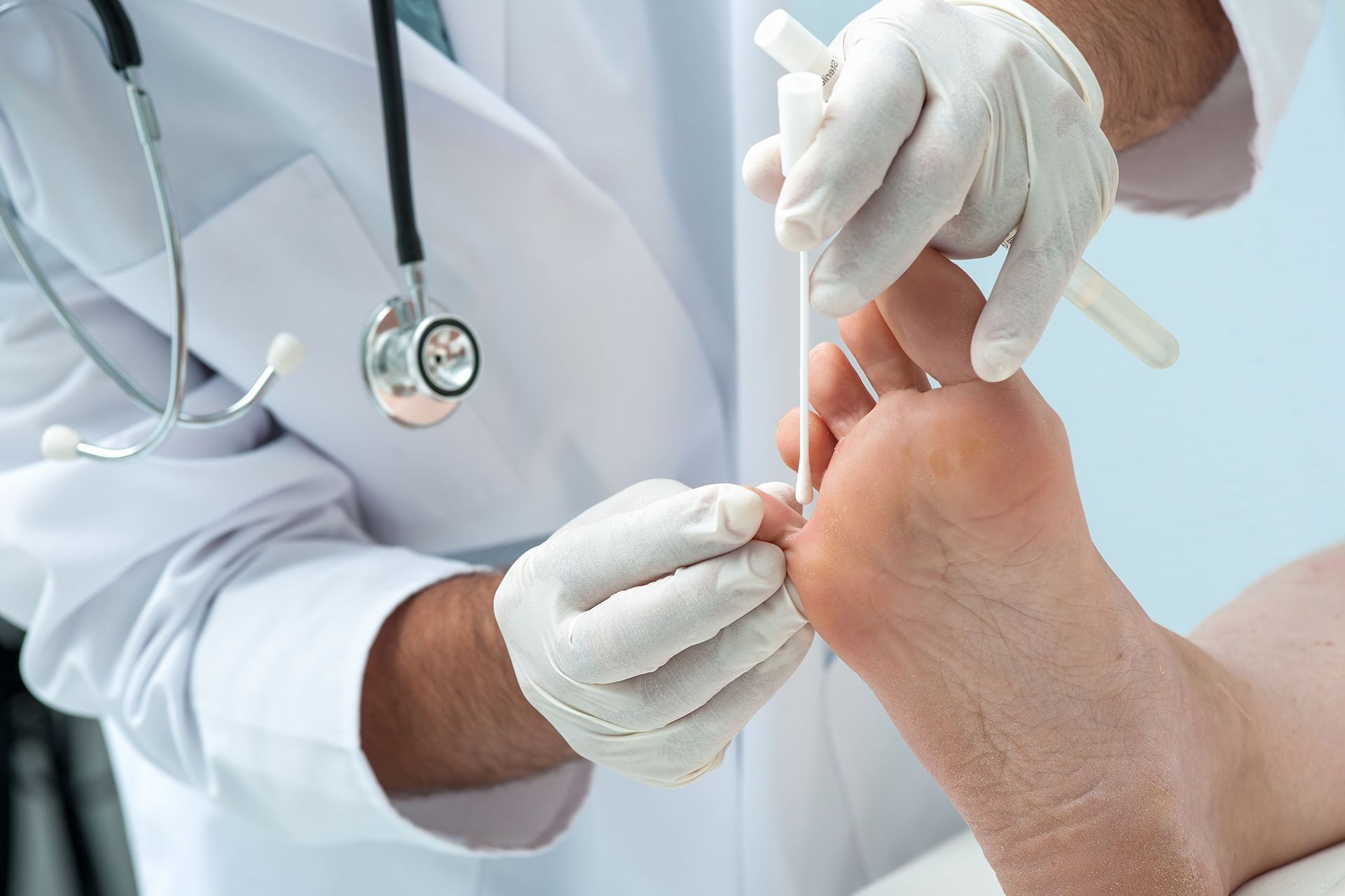 A doctor is examining a patient 's foot with a stethoscope.