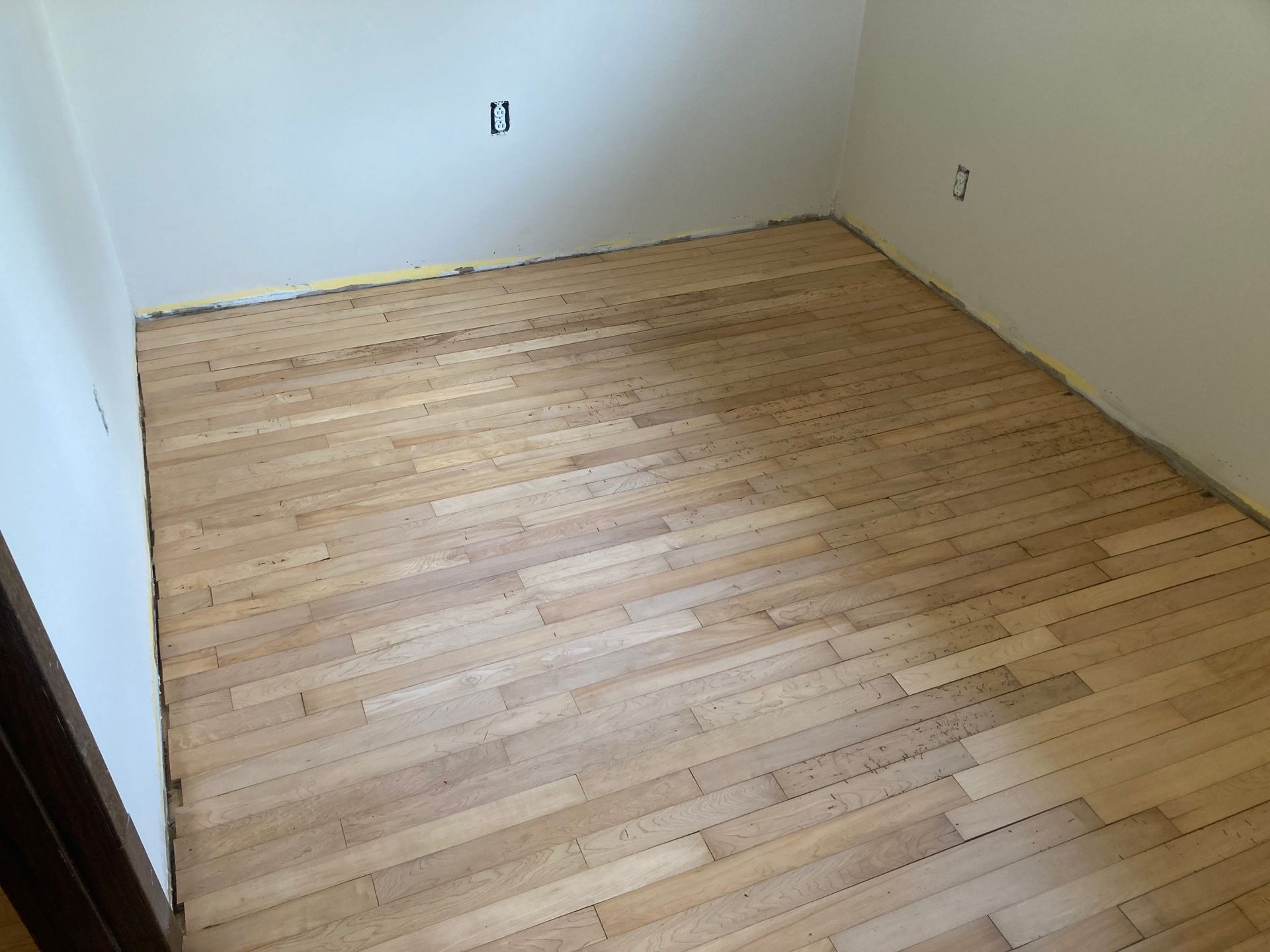 A room with a wooden floor and white walls.