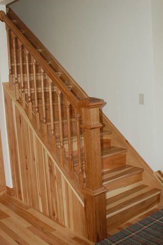 A wooden staircase with a wooden railing in a house.