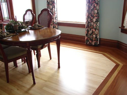 A dining room with a wooden table and chairs